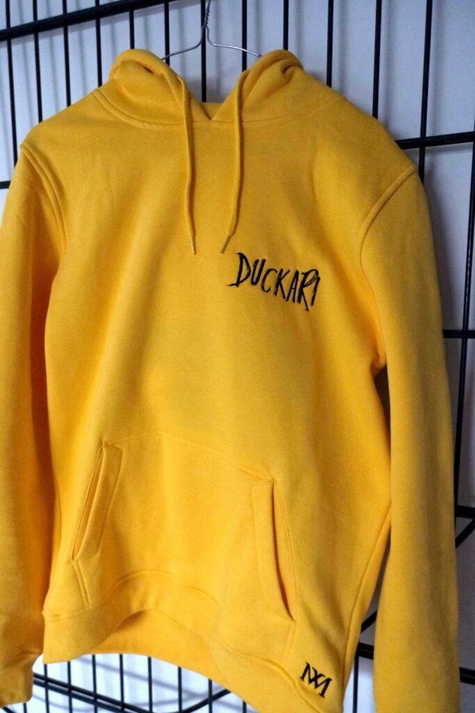 Gelber Duckari Hoodie von vorne, Schriftzug «Duckari» in Schwarz auf der Brust