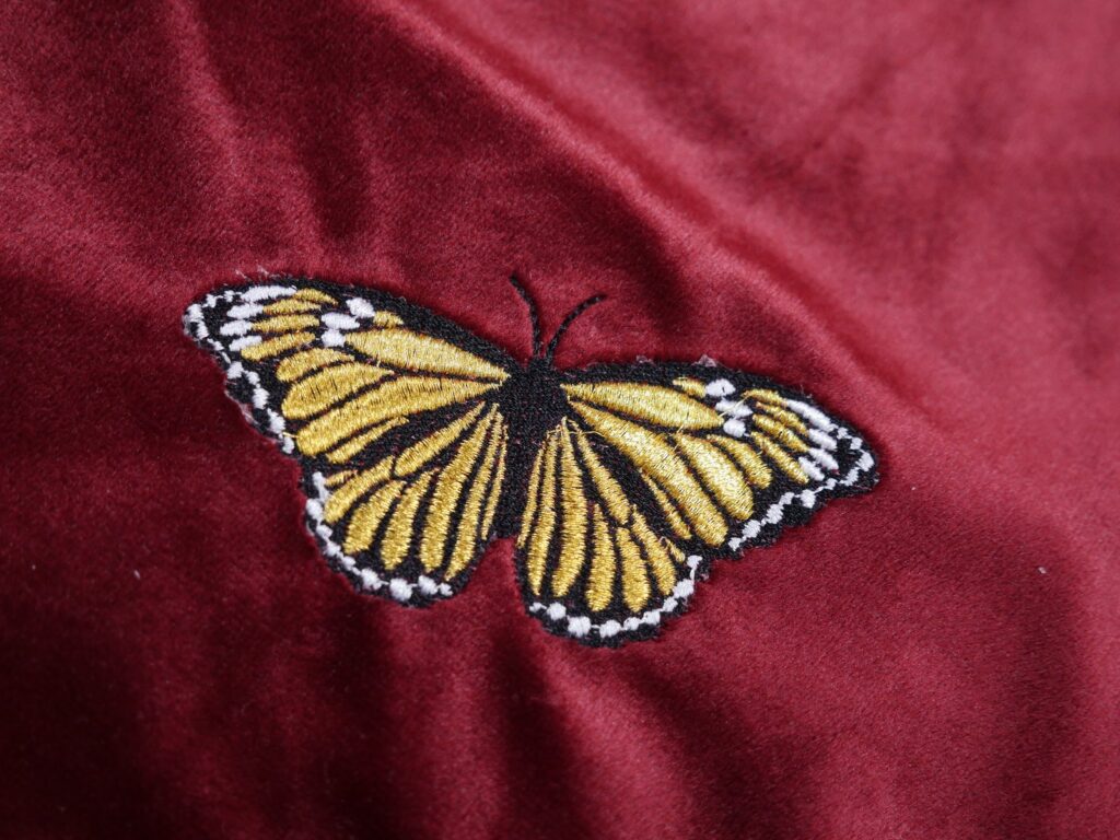 Rote Samttasche als Geschenkverpackung, bestickt mit einem goldenen Schmetterling