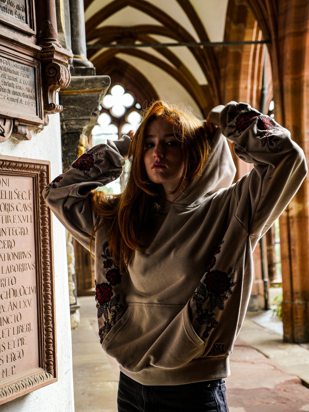Oversize Hoodie mit Blumenstickerei an Ärmeln und Seiten, Model im Kreuzgang