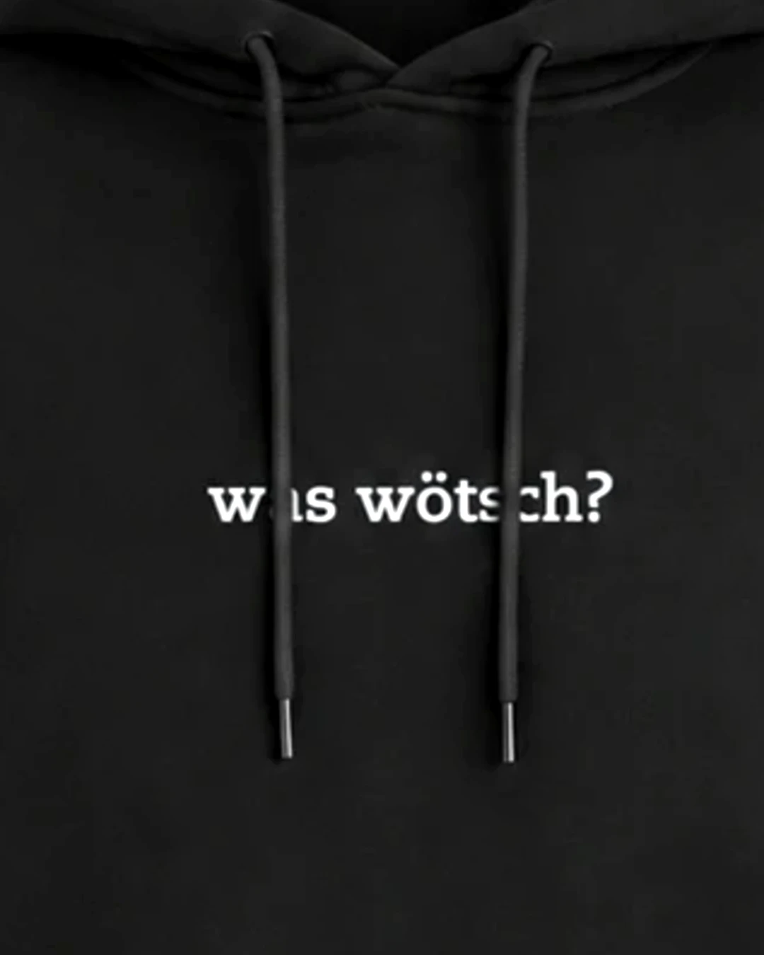 Nahaufnahme der Stickerei: "Was wötsch?" – Hoodie